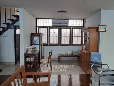 Charming interior with wooden furniture and large windows in a cozy living space.