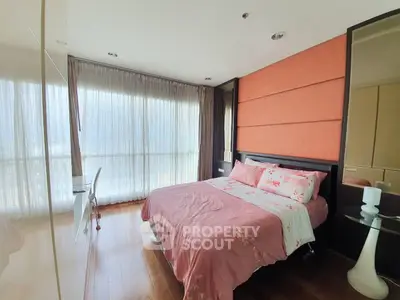 Spacious bedroom with large windows and elegant decor in modern apartment.