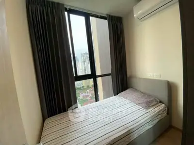 Cozy bedroom with city view, featuring a comfortable bed and air conditioning.