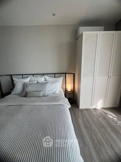 Modern bedroom with stylish decor and ample natural light, featuring a cozy bed and sleek wardrobe.