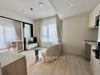Modern living room with open layout and natural light, featuring sleek furniture and stylish decor.