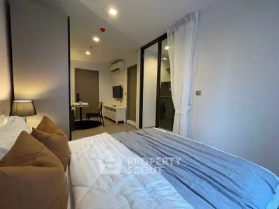 Modern bedroom with cozy bedding and stylish decor in a contemporary apartment.