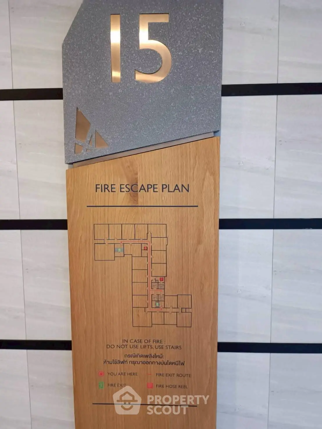 Fire escape plan on a wooden panel for floor 15 in a modern building.