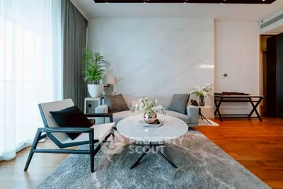 Modern living room with elegant furniture and marble accent wall, featuring a cozy seating area and stylish decor.