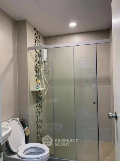 Modern bathroom with glass shower enclosure and tiled walls