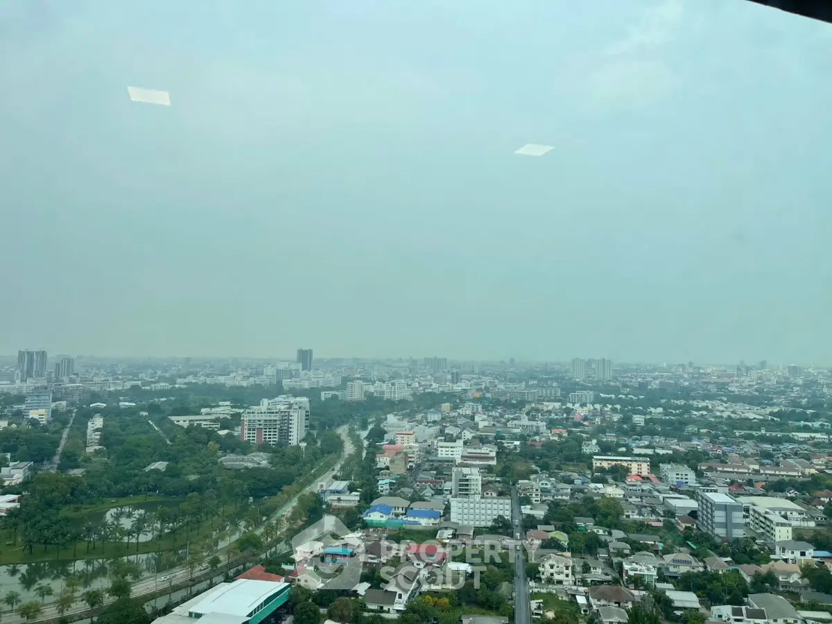 Stunning cityscape view from high-rise building showcasing urban landscape and greenery.