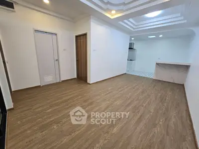 Spacious modern living room with elegant ceiling design and open kitchen layout