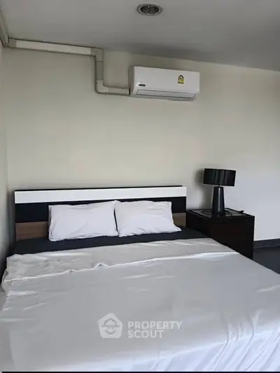 Modern bedroom with air conditioning and stylish lamp, perfect for comfortable living.