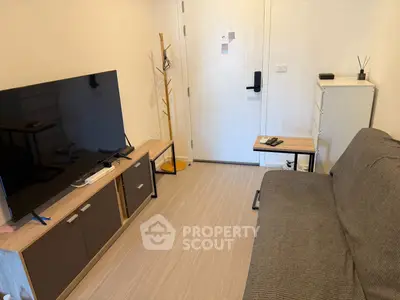 Cozy living room with modern TV setup and comfortable sofa in a stylish apartment.
