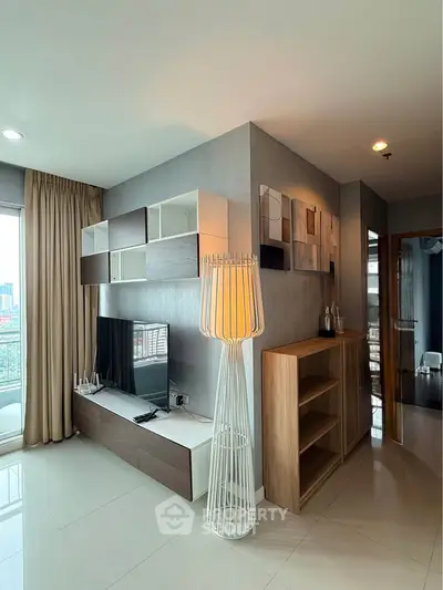 Modern living room with stylish decor and city view, featuring a sleek TV unit and elegant lighting.
