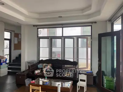 Spacious living room with large windows and modern furniture, perfect for family gatherings.