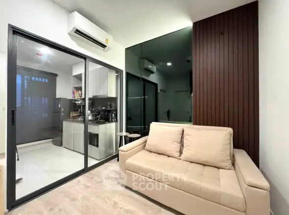 Modern living room with sleek design and open kitchen layout, featuring air conditioning and stylish decor.