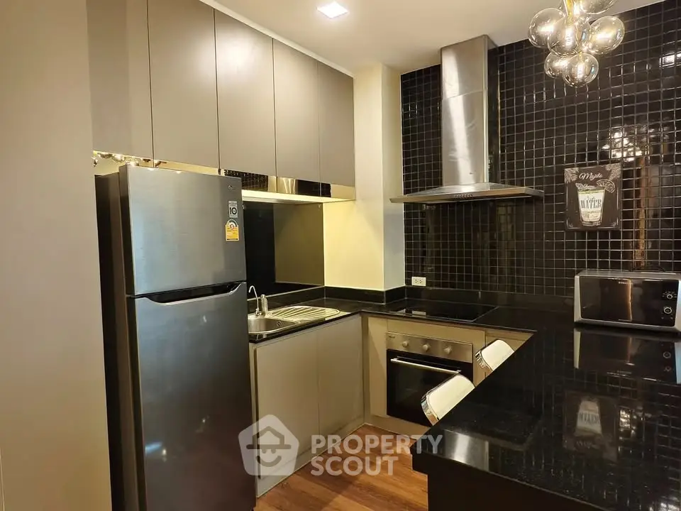 Modern kitchen with sleek black tiles and stainless steel appliances