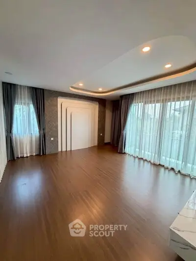 Spacious modern living room with elegant ceiling design and large windows