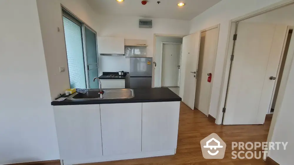 Modern kitchen with sleek design and wooden flooring in a stylish apartment.