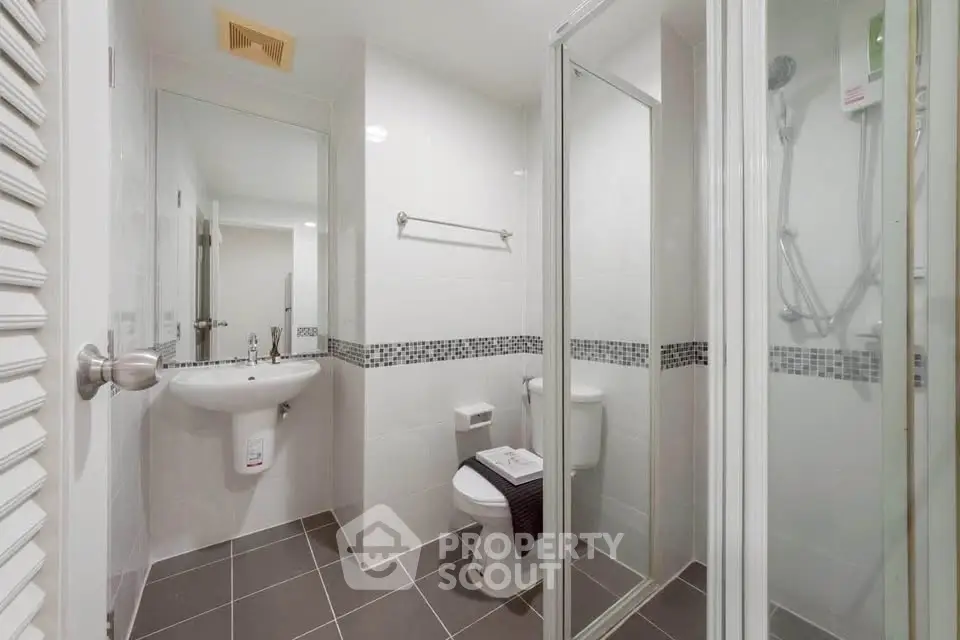 Modern bathroom with glass shower and sleek fixtures in a contemporary home.