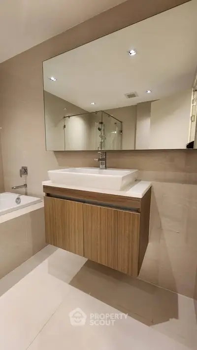 Modern bathroom with sleek vanity and large mirror in luxury apartment