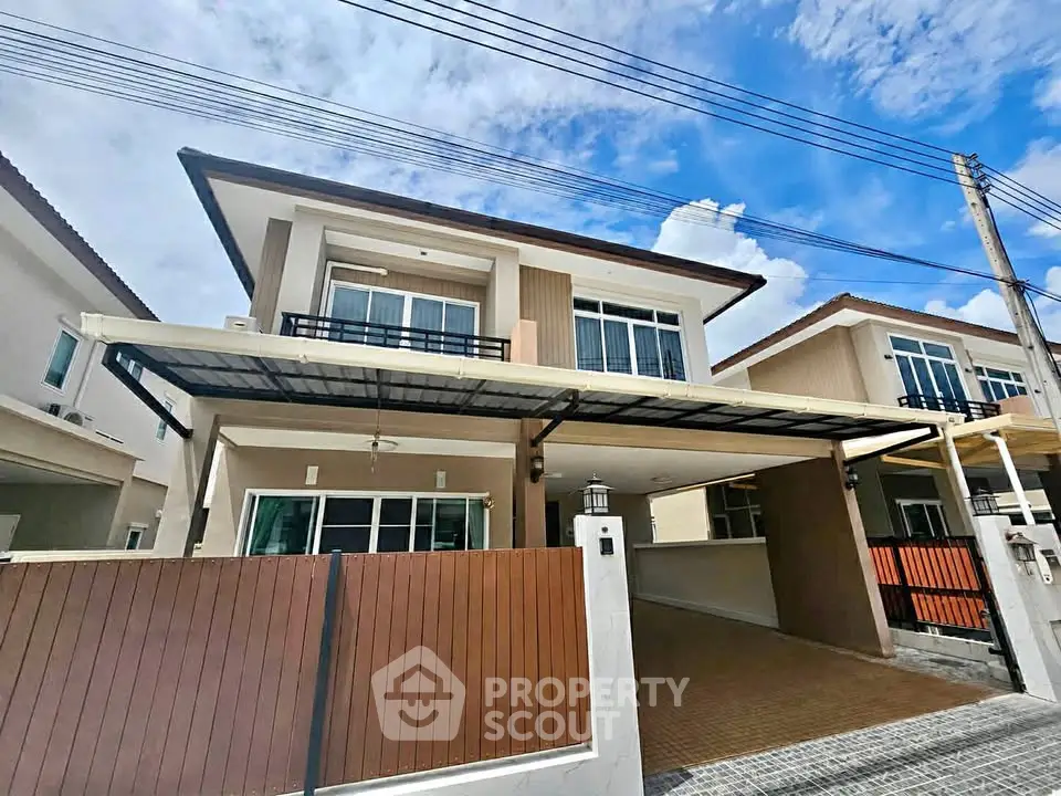 Modern two-story house with spacious driveway and stylish facade under a clear blue sky.