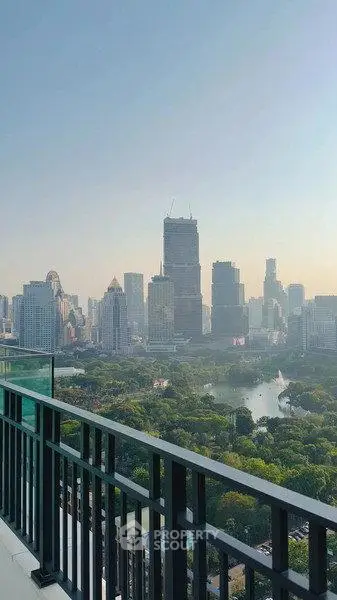 Stunning cityscape view from a high-rise balcony overlooking lush park and skyline.
