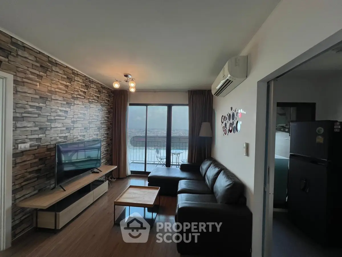 Modern living room with stylish decor and balcony view, featuring a cozy seating area and entertainment setup.