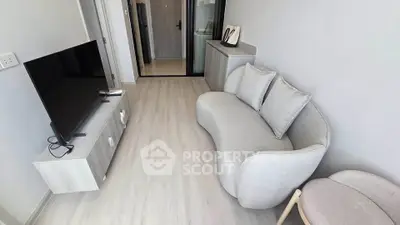 Modern living room with stylish sofa and flat-screen TV in a cozy apartment.