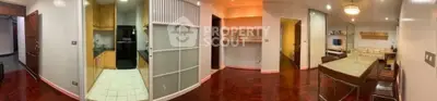 Spacious open-plan living and dining area with modern kitchen and elegant wooden flooring.
