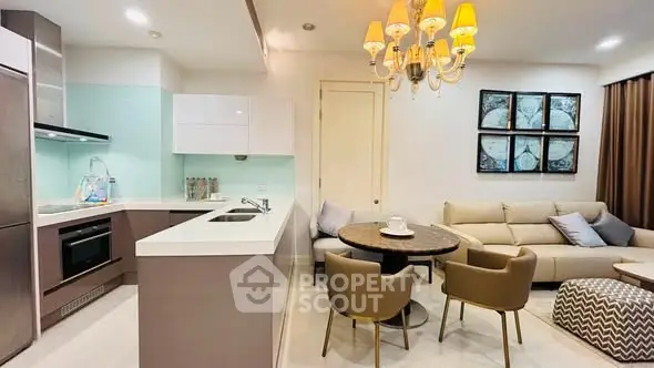 Modern open-layout kitchen and living room with elegant lighting and stylish furniture.