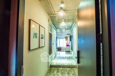 Stylish apartment entrance with modern lighting and open view to living area.