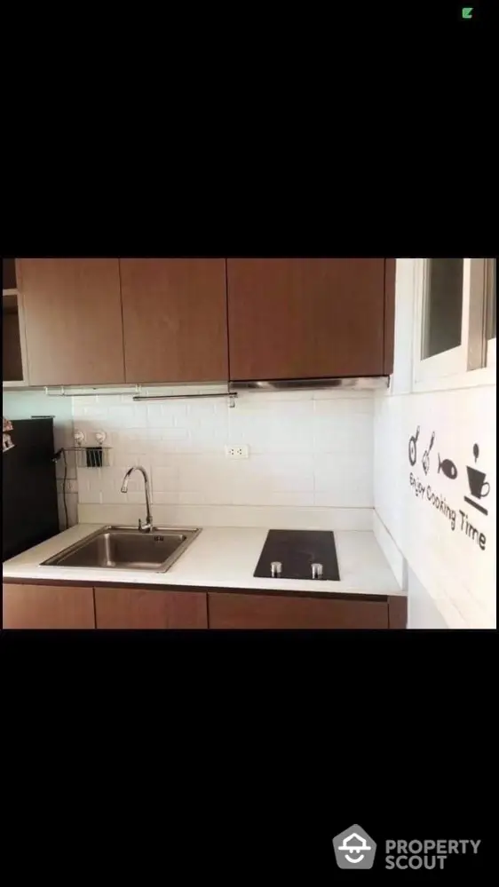 Modern kitchen with sleek cabinetry and electric cooktop, perfect for culinary enthusiasts.