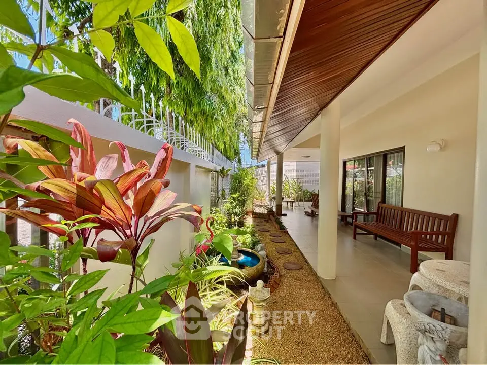 Charming garden view of a modern home with lush greenery and inviting outdoor seating area.