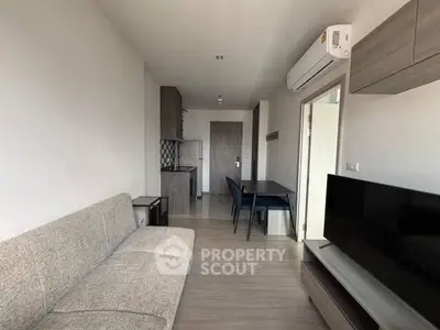 Modern living room with sleek furniture and open kitchen layout in a stylish apartment.