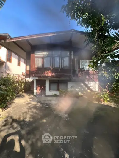 Charming wooden house with lush garden and spacious driveway, perfect for serene living.