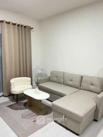 Modern living room with beige sectional sofa, stylish armchair, and elegant coffee table.