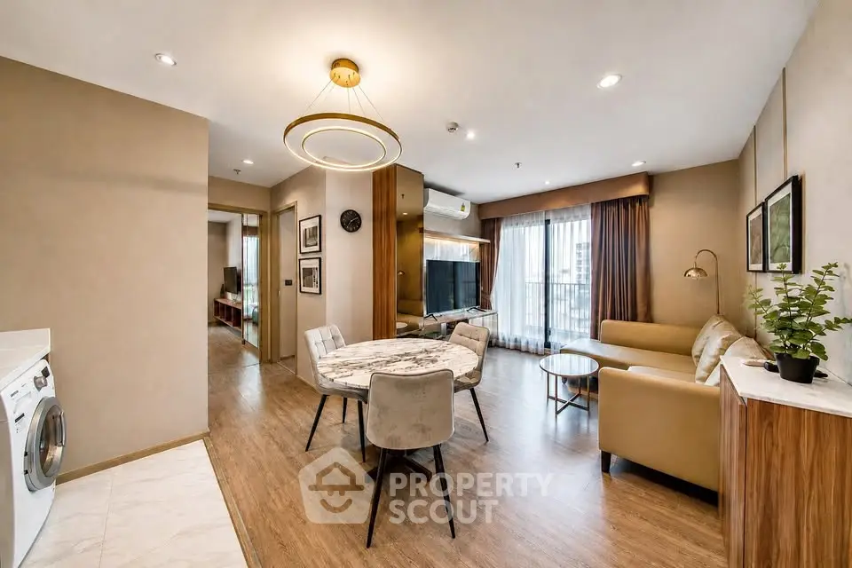 Modern living room with elegant decor and open layout, featuring a cozy seating area and stylish dining space.