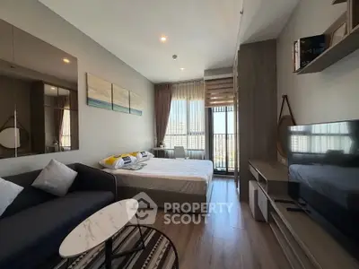 Modern studio apartment with stylish decor and natural light, featuring a cozy living area and balcony view.