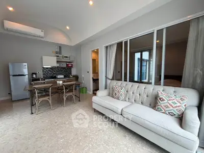 Modern open-plan living room with stylish kitchen and cozy seating area.