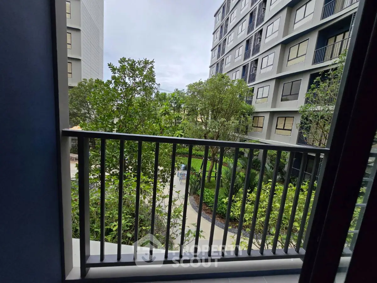 Modern apartment building with lush garden view from balcony