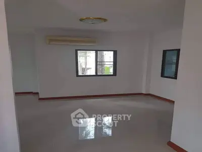 Spacious empty room with large windows and air conditioning, perfect for customization.