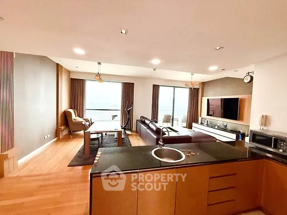 Spacious open-plan living room with modern kitchen and stunning view.