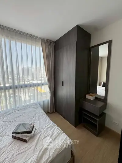Modern bedroom with large window and stylish wardrobe in a high-rise apartment.