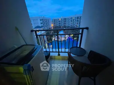 Charming balcony with pool view, perfect for relaxation in a modern apartment complex.