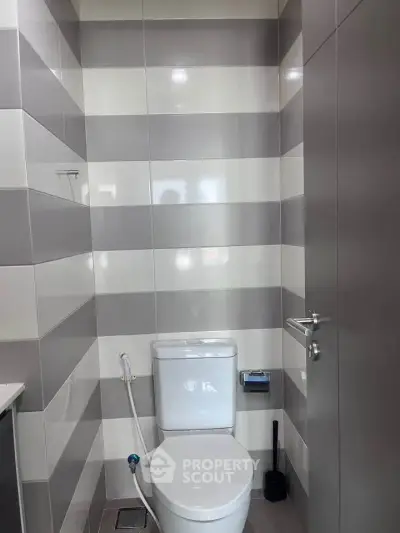 Modern bathroom with sleek striped tiles and contemporary fixtures.