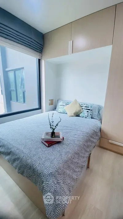 Cozy bedroom with modern decor and large window for natural light