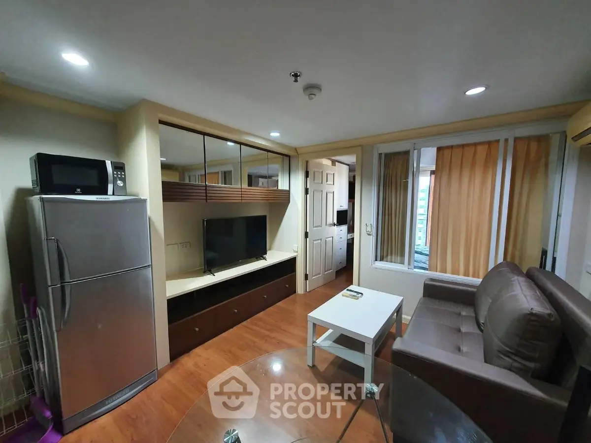 Cozy living room with modern appliances and stylish decor in a compact apartment.
