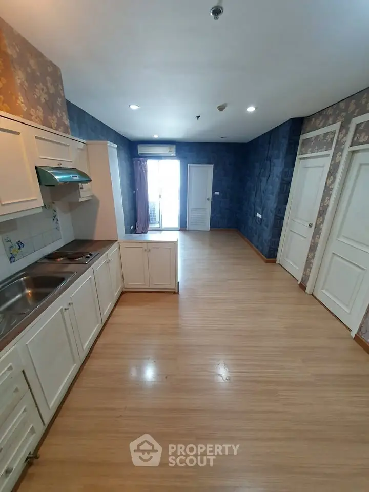 Spacious kitchen with open layout and wooden flooring in modern apartment