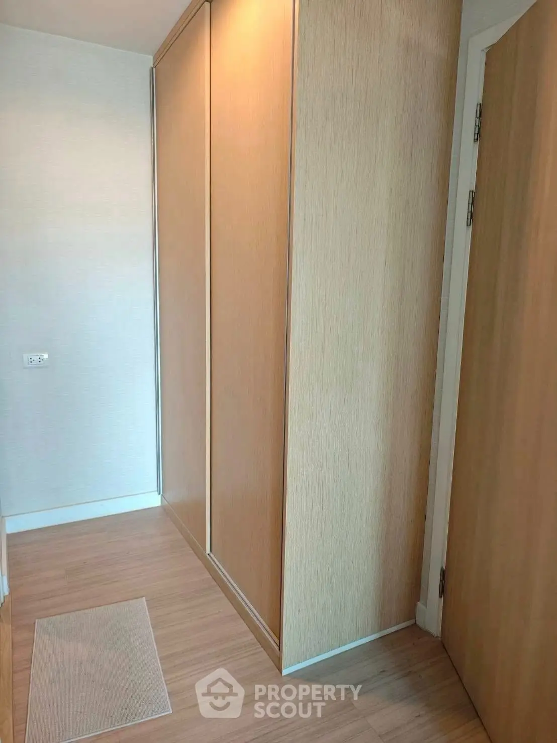 Modern storage space with sleek wooden cabinetry and minimalist design.