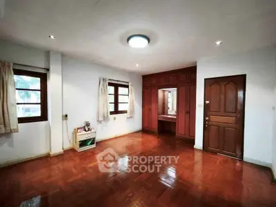 Spacious bedroom with wooden flooring and built-in wardrobe