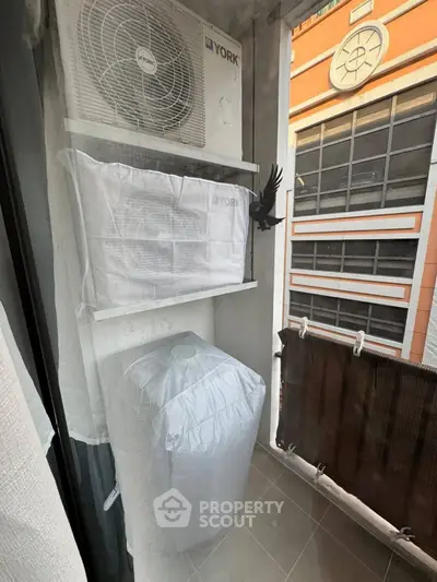 Compact balcony with air conditioning unit and city view