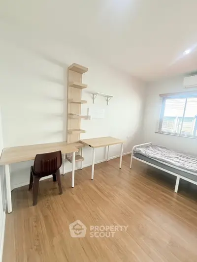 Minimalist bedroom with wooden flooring and study desk