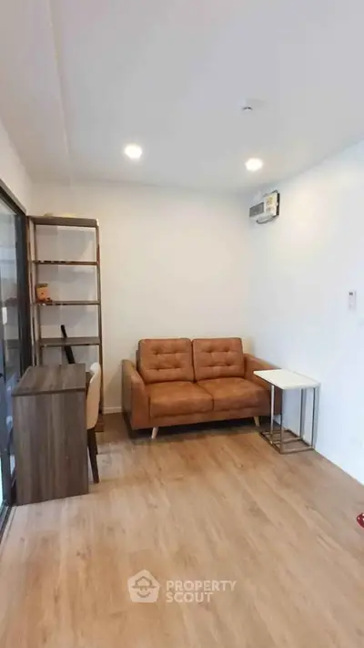 Modern living room with brown leather sofa and wooden flooring